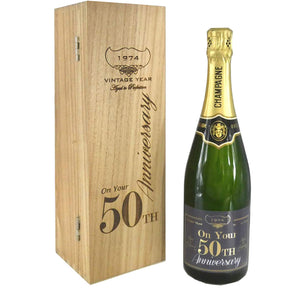 Bouteille de champagne de 75 cl personnalisée pour le 50e anniversaire, présentée dans une boîte en bois gravée.